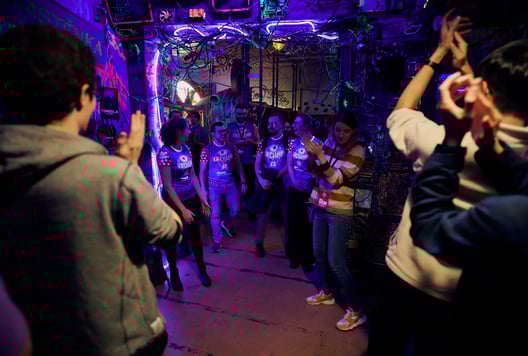 People are cheering and welcoming players as they leave the escape room.