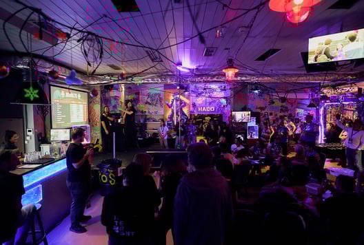 Teams are watching the final results of the Escape Room Championship on the screen.