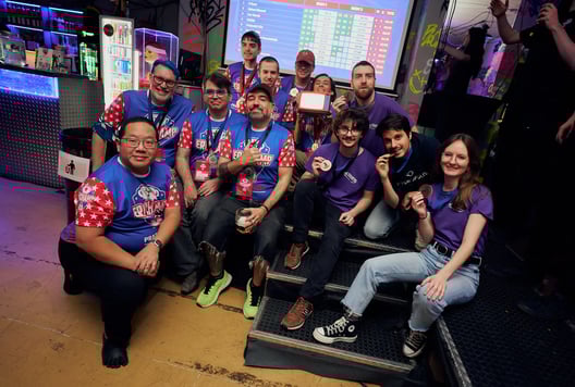 All medal-winning teams are posing together with their medals and the prize.