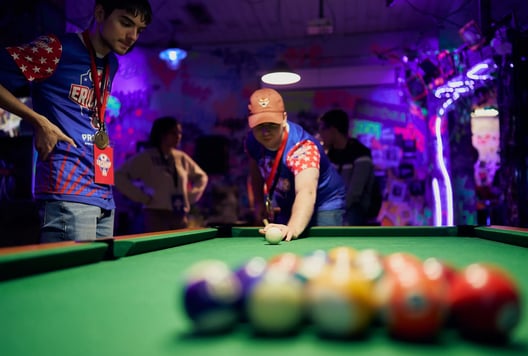 Two players are playing pool and relaxing after their escape room games.