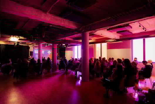 A conference room is filled with attendees listening to a presentation.