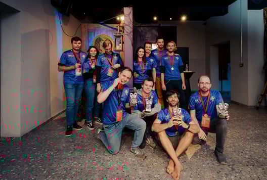 A larger group of medal-winners proudly gathers together for a team photo with their trophies.