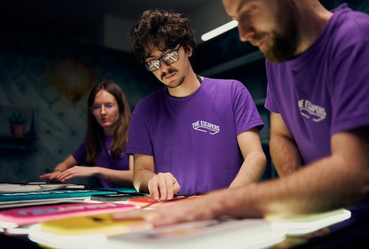 The Escapers team is focused while working on a task inside the escape room.